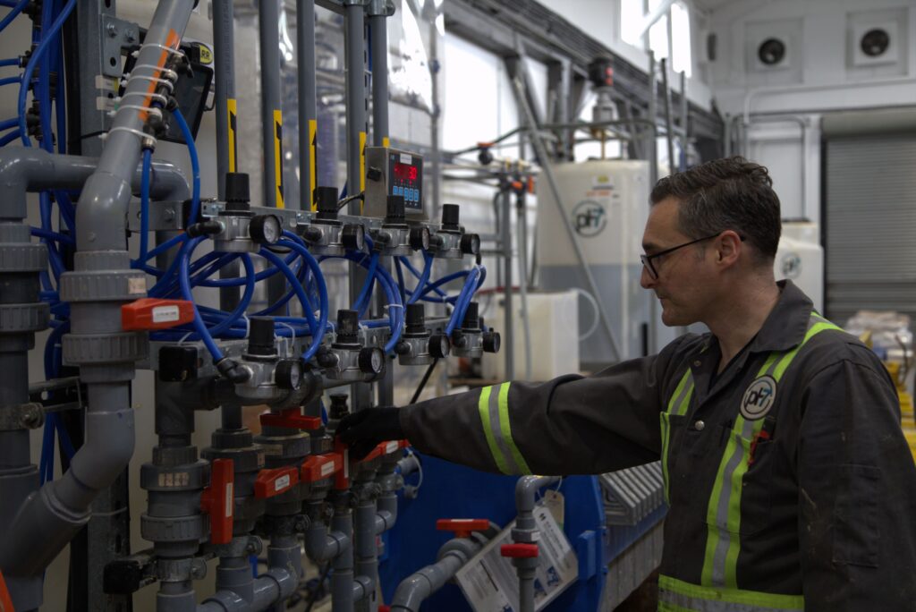 A man in a uniform is working inside the pH7 Technologies metal extraction plant.